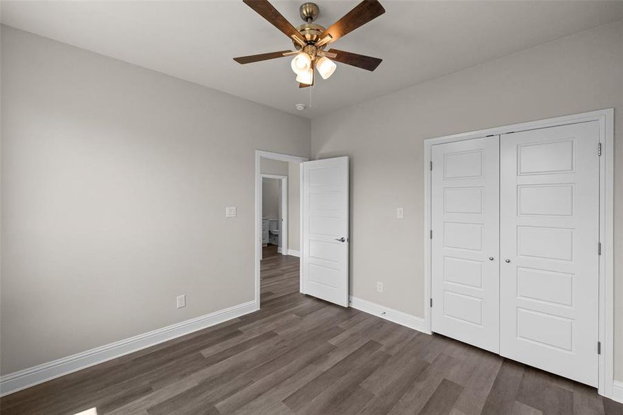 Unfurnished bedroom with a closet, ceiling fan, and dark hardwood / wood-style floors