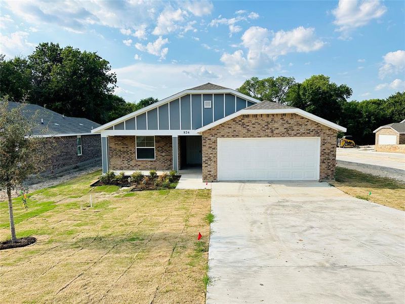 View of front of house with a garage and a front yard