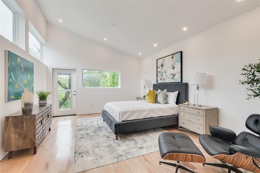 Light filled primary bedroom with deck overlooking the creek lot.