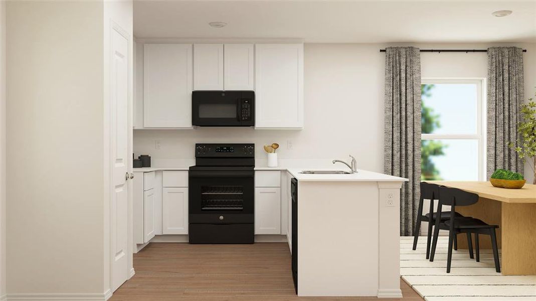 Kitchen with white cabinetry, kitchen peninsula, light hardwood / wood-style floors, black appliances, and sink