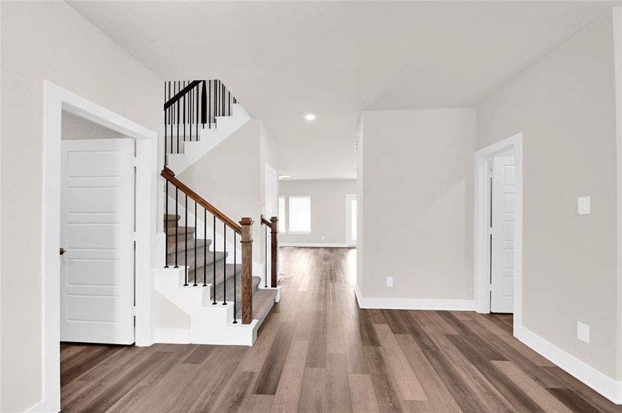 Step inside and fall in love! Upon entry, you're greeted with stunning luxury vinyl plank flooring, fresh neutral paint, an elegant chandelier, and access into the Den, attached garage, powder bath, and in-home utility room.