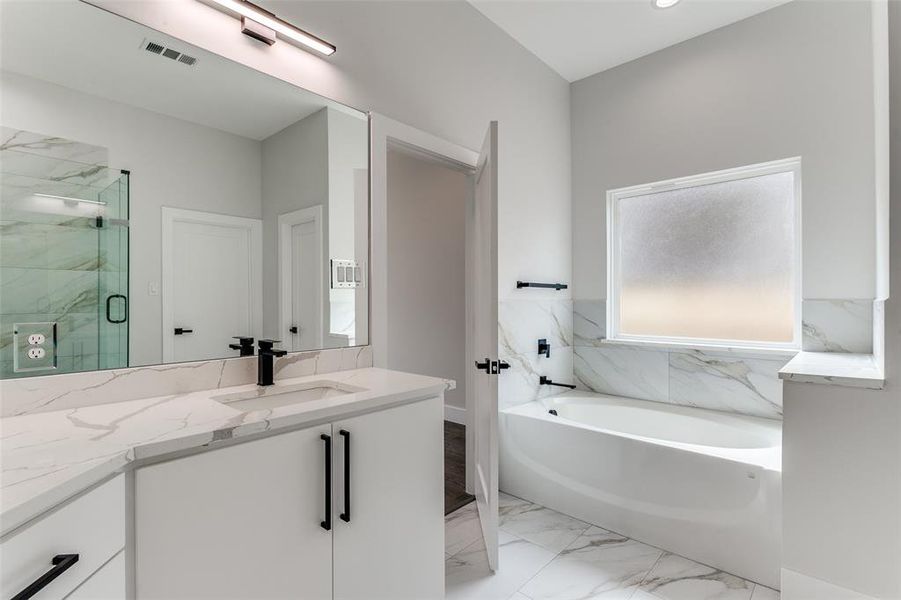 Bathroom with separate shower and tub, tile floors, and large vanity