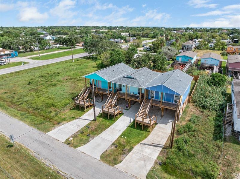 Drone view of the blue home with a gray roof.