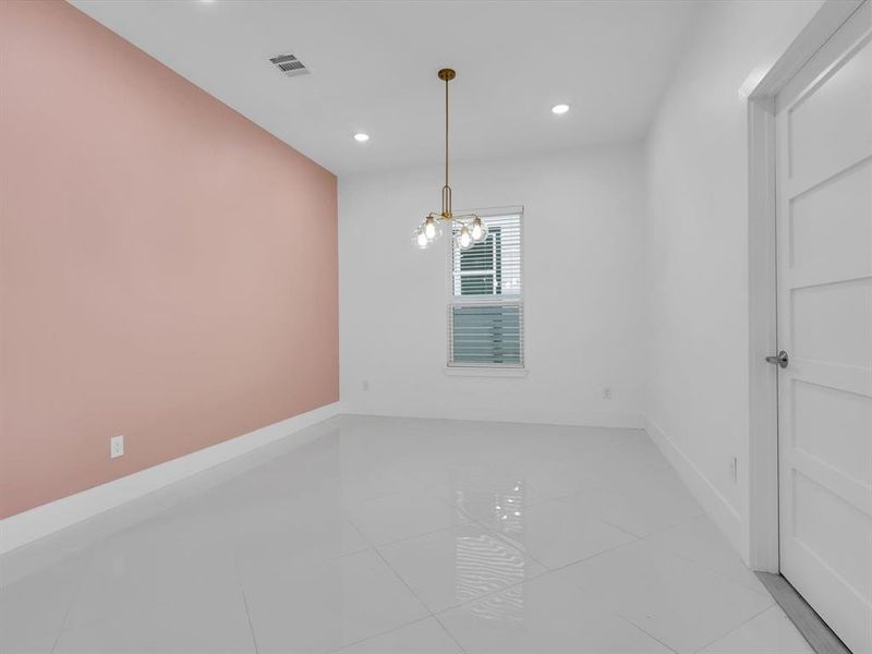 Tiled spare room with a chandelier