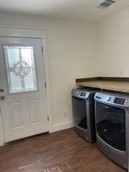 Clothes washing area featuring separate washer and dryer and dark hardwood / wood-style flooring