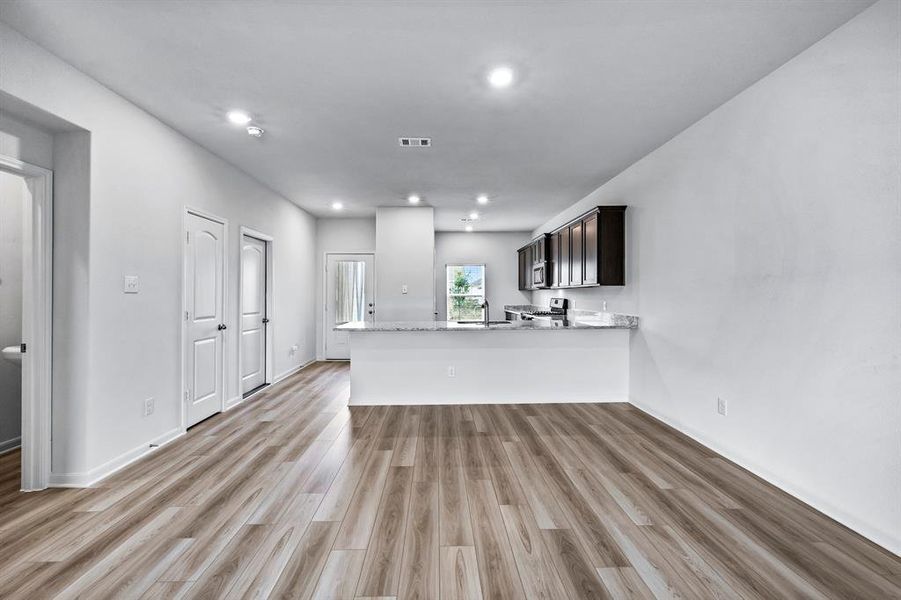 Unfurnished living room featuring sink and light wood-type flooring