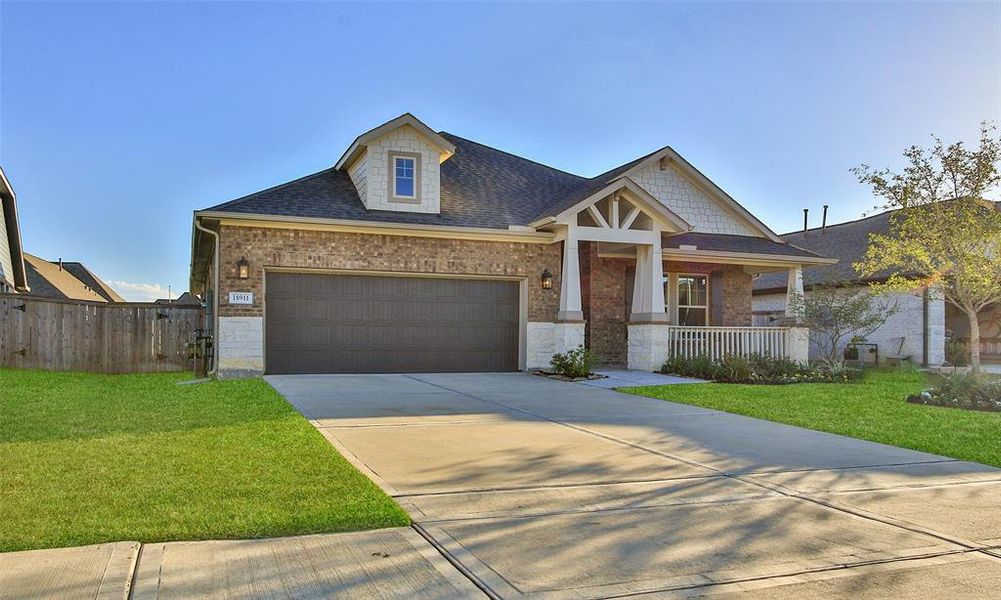 This is a modern single-story home featuring a covered patio and an inviting in-ground pool, complemented by a neatly manicured lawn and a privacy fence.