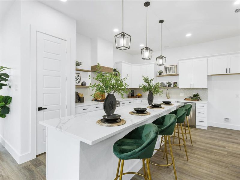 Kitchen featuring light hardwood / wood-style floors, a breakfast bar area, white cabinets, and tasteful backsplash