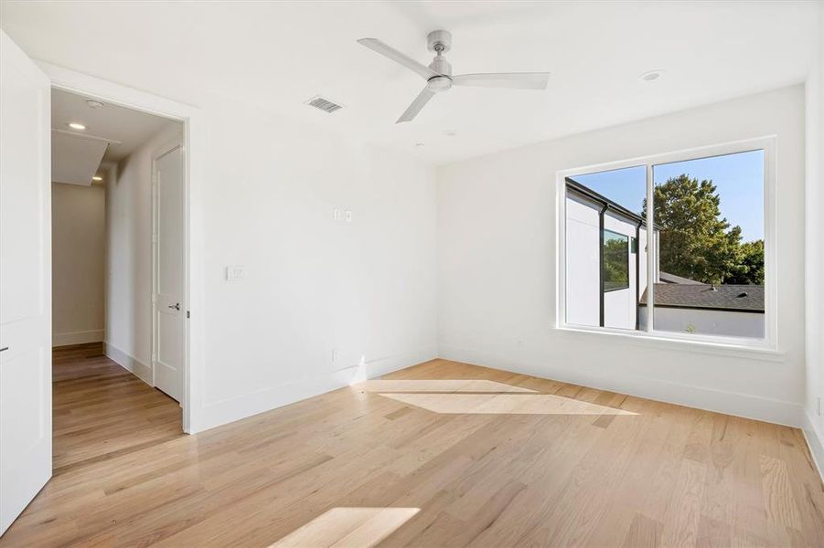 Empty room with light hardwood / wood-style floors and ceiling fan