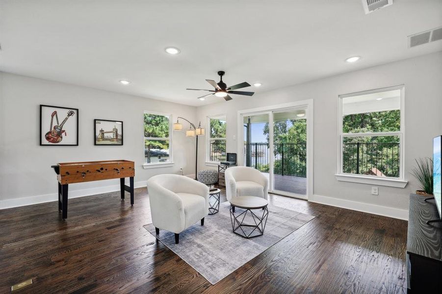 Living area featuring dark hardwood / wood-style floors, ceiling fan, and a wealth of natural light