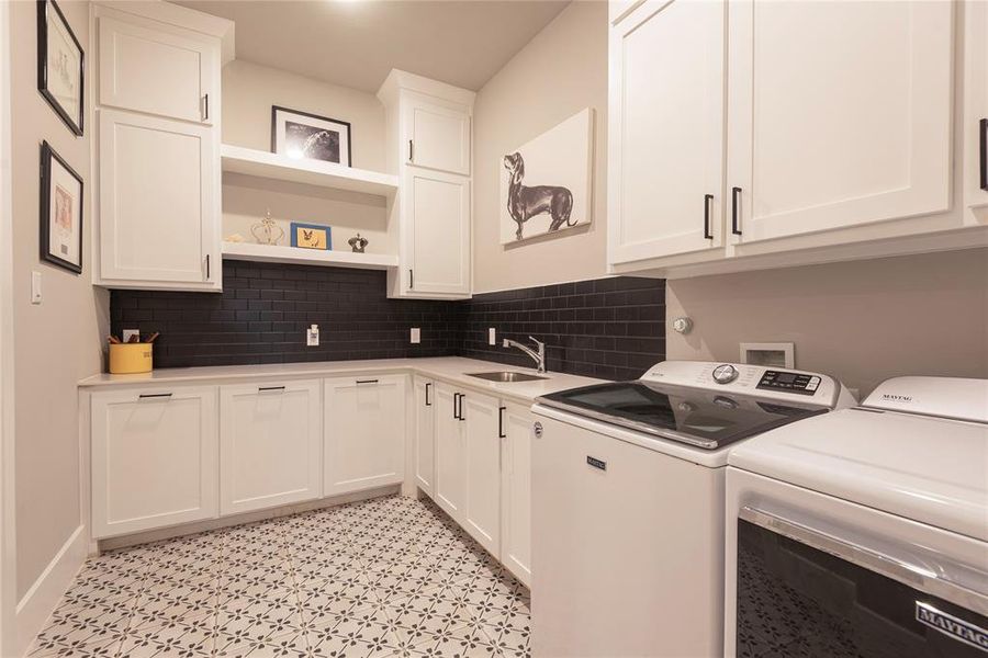 Adjacent to primary Closet is your laundry room complete with sink, cabinets and beautiful floor design.