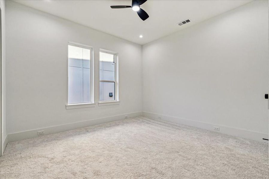 Carpeted spare room featuring ceiling fan