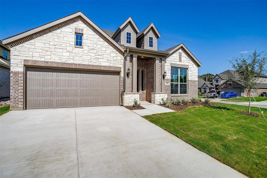 View of front of home with a front lawn and a garage