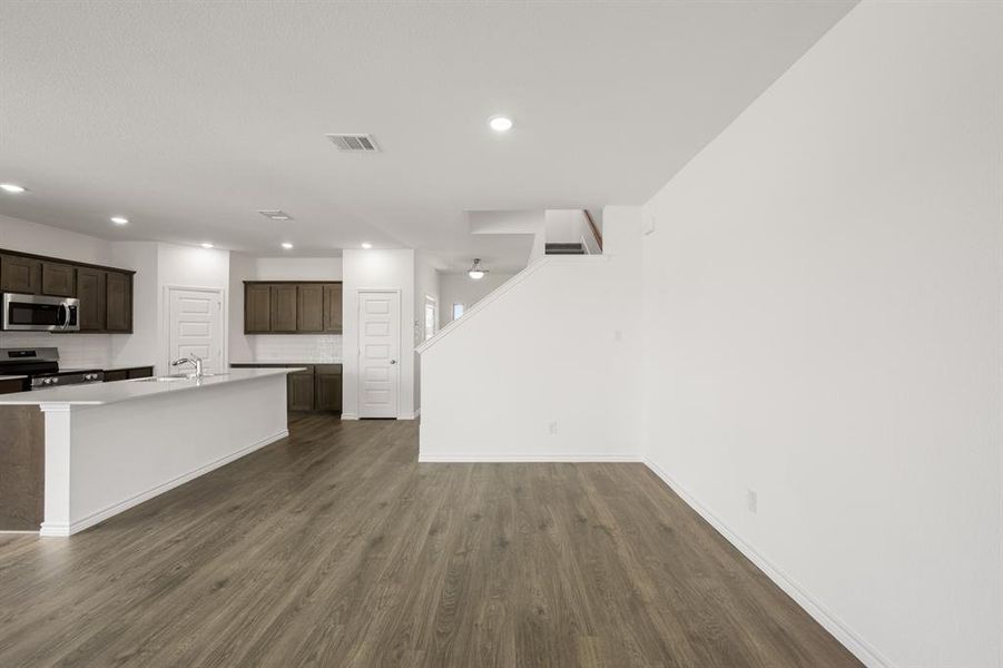 Unfurnished living room with ceiling fan and dark hardwood / wood-style floors