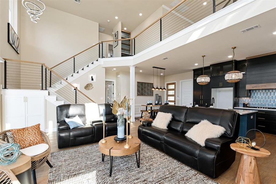 Living room featuring light wood-type flooring and a towering ceiling