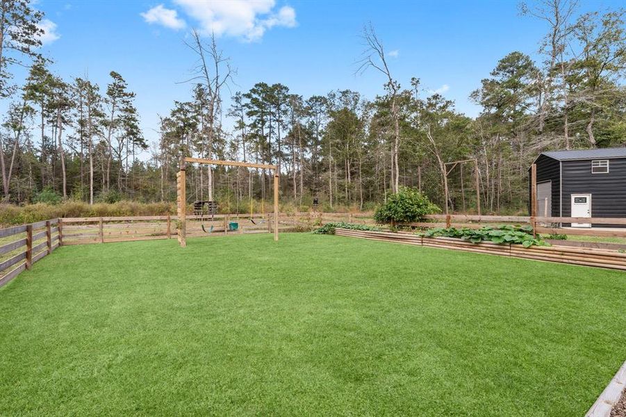 Fenced in yard with a play area