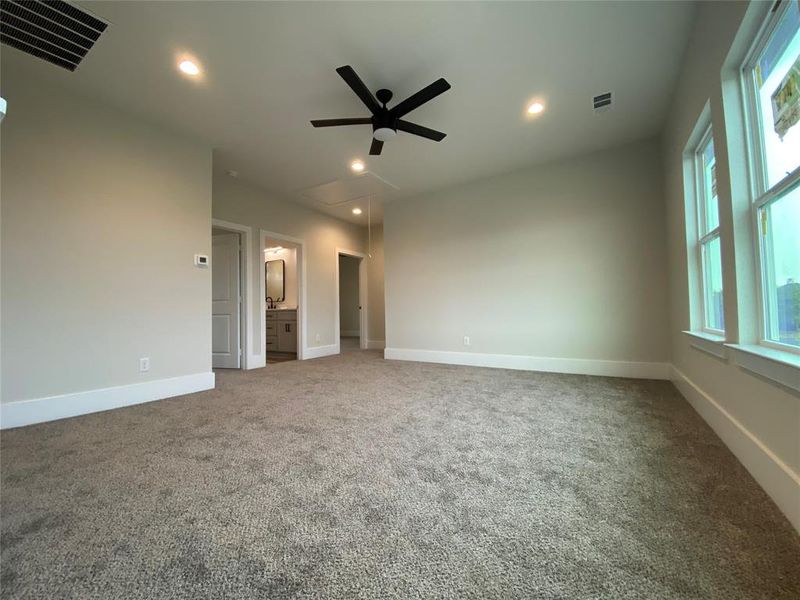 Carpeted empty room featuring a healthy amount of sunlight and ceiling fan