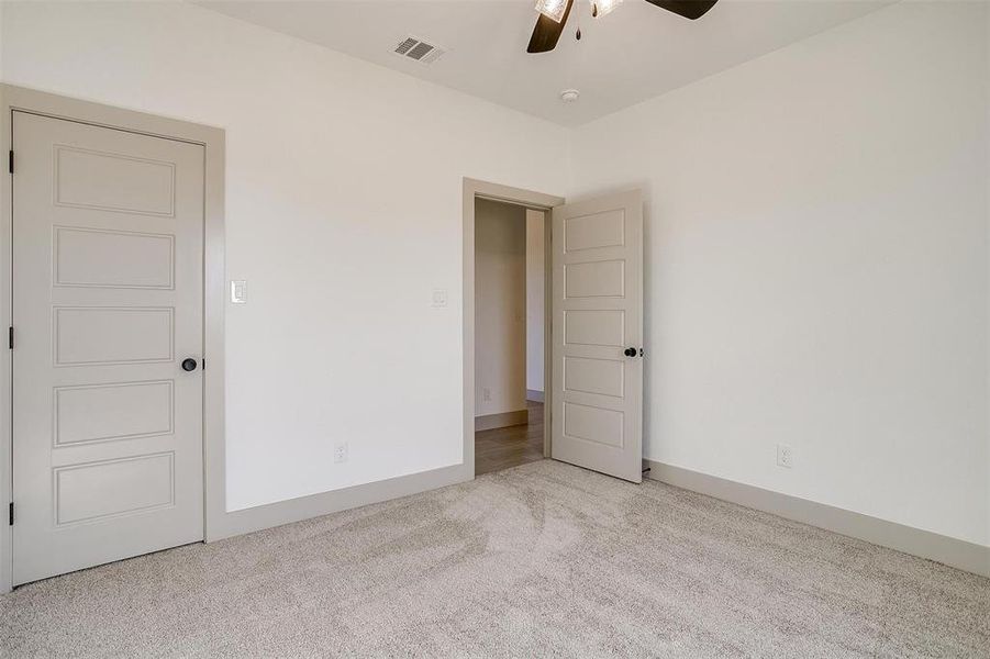 Empty room with light carpet and ceiling fan