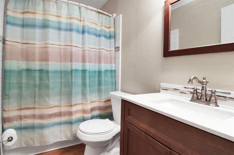 Bathroom featuring toilet, hardwood / wood-style floors, and vanity