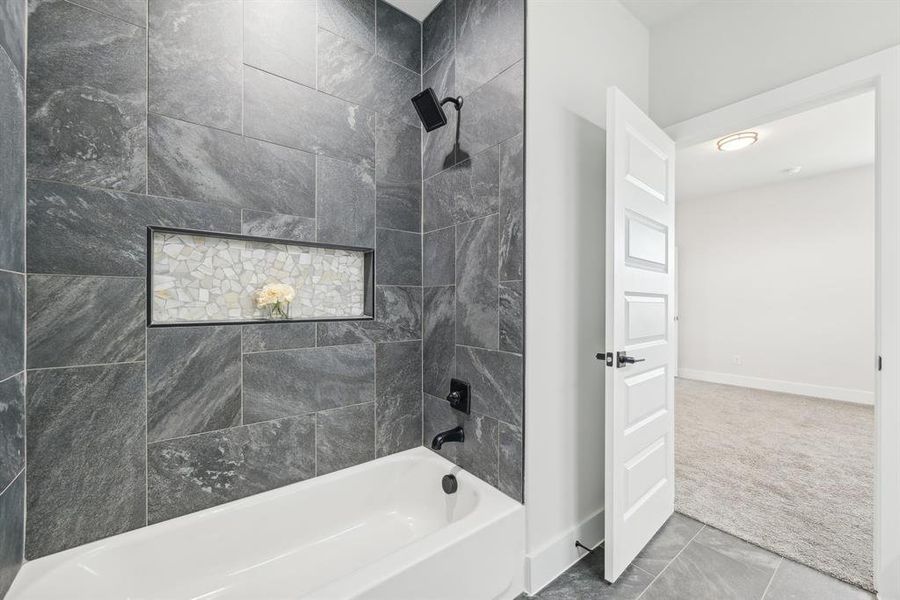 Bathroom featuring tiled shower / bath and tile patterned floors