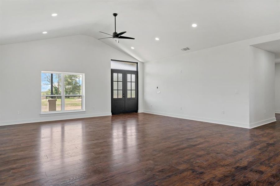 Unfurnished living room with french doors, dark hardwood / wood-style flooring, ceiling fan, and high vaulted ceiling