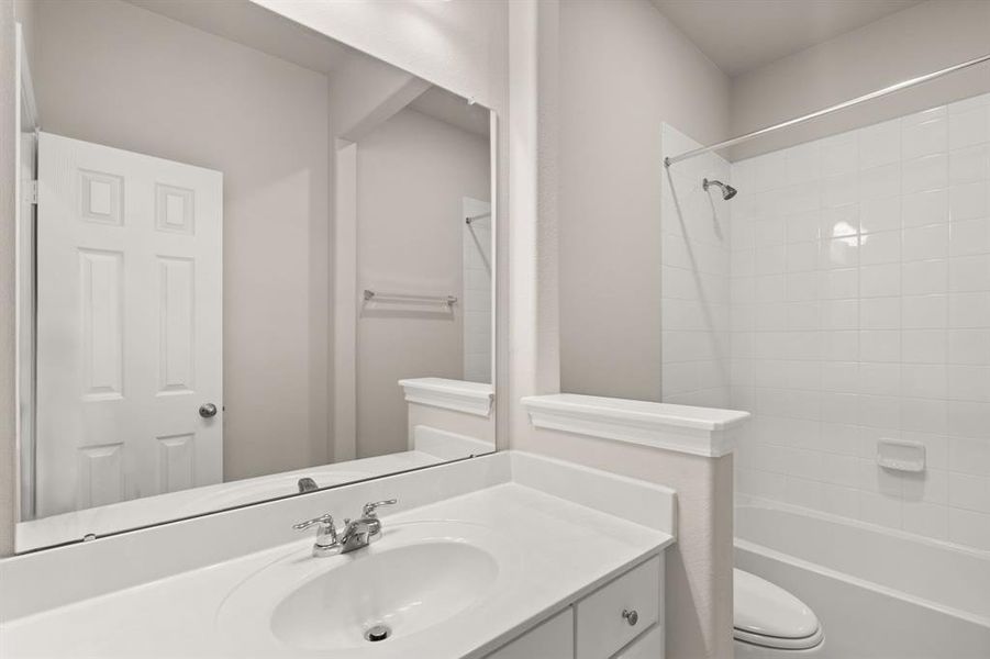 The secondary bath features tile flooring, white cabinetry and light countertops and a shower/tub combo. Perfect for accommodating any visiting family and friends.