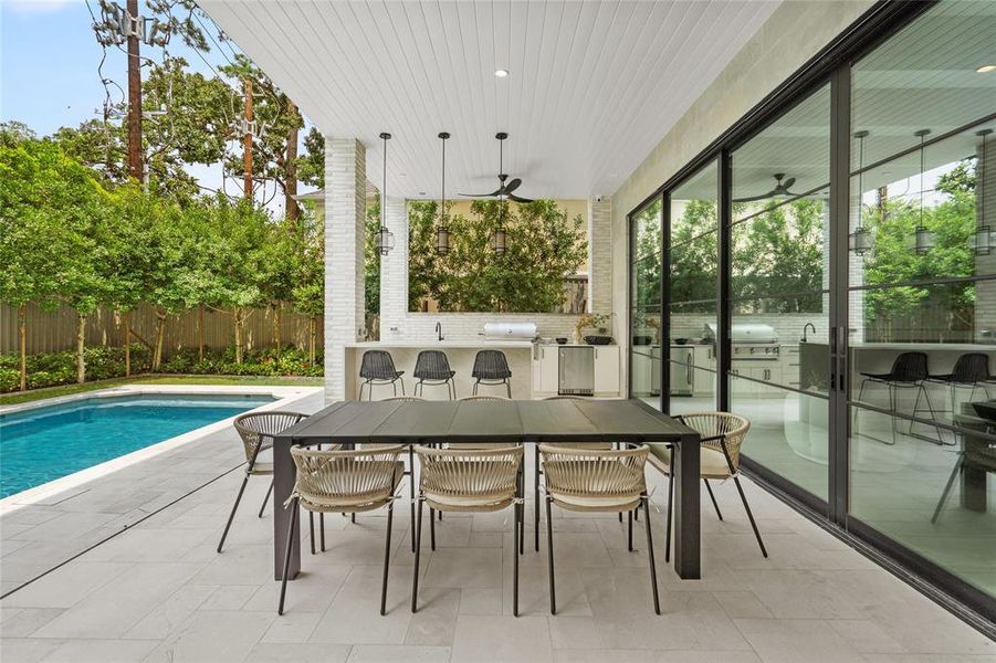 A wall of glass doors seamlessly connects the veranda to the family room, offering easy access and stunning views of the beautifully landscaped pool and backyard. This versatile space is ideal for entertaining or relaxing, blending style and functionality.