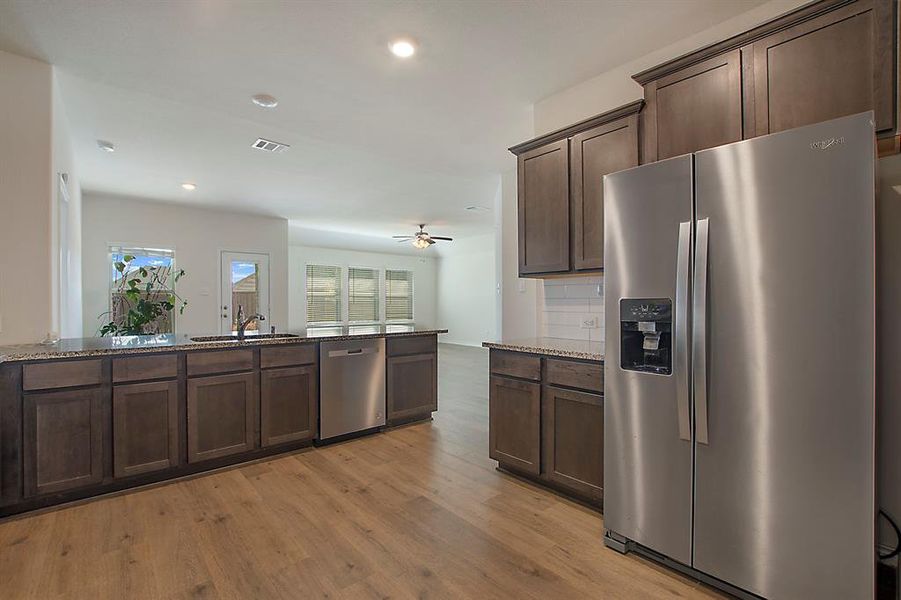 Kitchen with sink, appliances with stainless steel finishes, light hardwood / wood-style floors, and plenty of natural light