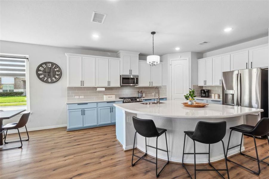 Discover culinary excellence in this inviting kitchen, boasting expansive Quartz countertops and an open layout perfect for hosting and cooking simultaneously.