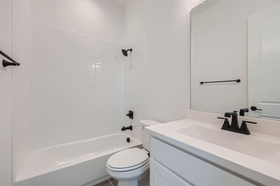 Full bathroom with vanity, toilet, and tiled shower / bath combo