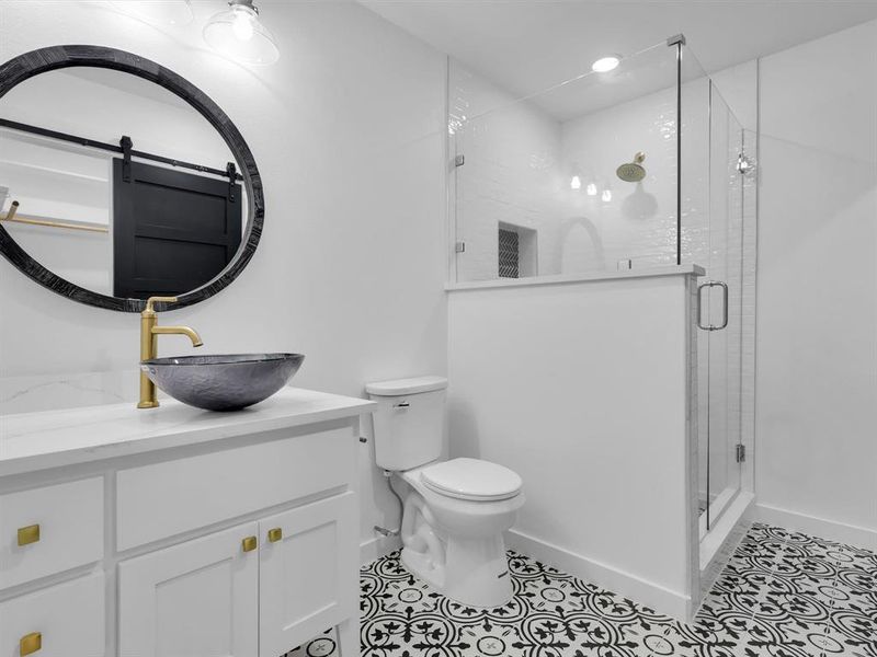 Bathroom featuring toilet, vanity, an enclosed shower, and tile patterned flooring