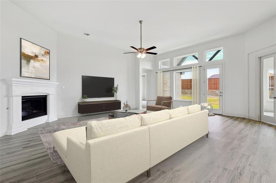 Living room featuring ceiling fan, hardwood / wood-style floors, and a healthy amount of sunlight