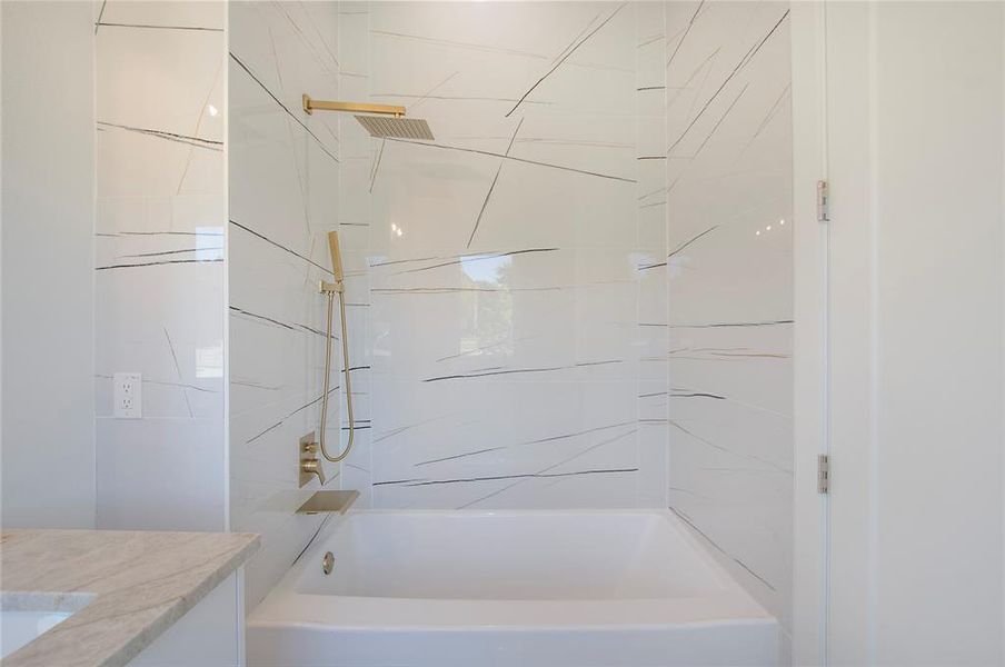 Bathroom featuring tiled shower / bath combo and vanity