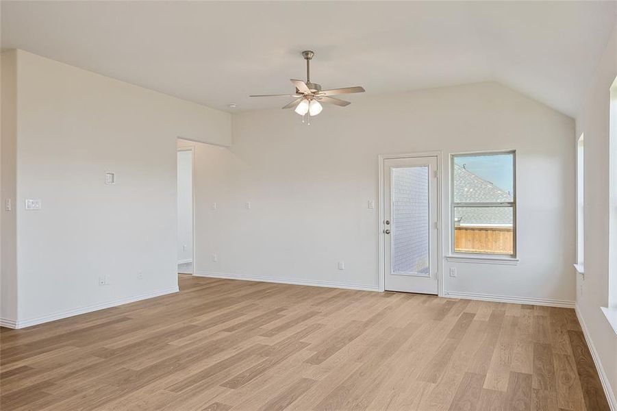 Spare room featuring light hardwood / wood-style floors, ceiling fan, and vaulted ceiling