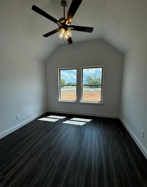 Bonus room featuring lofted ceiling, ceiling fan, and dark hardwood / wood-style flooring