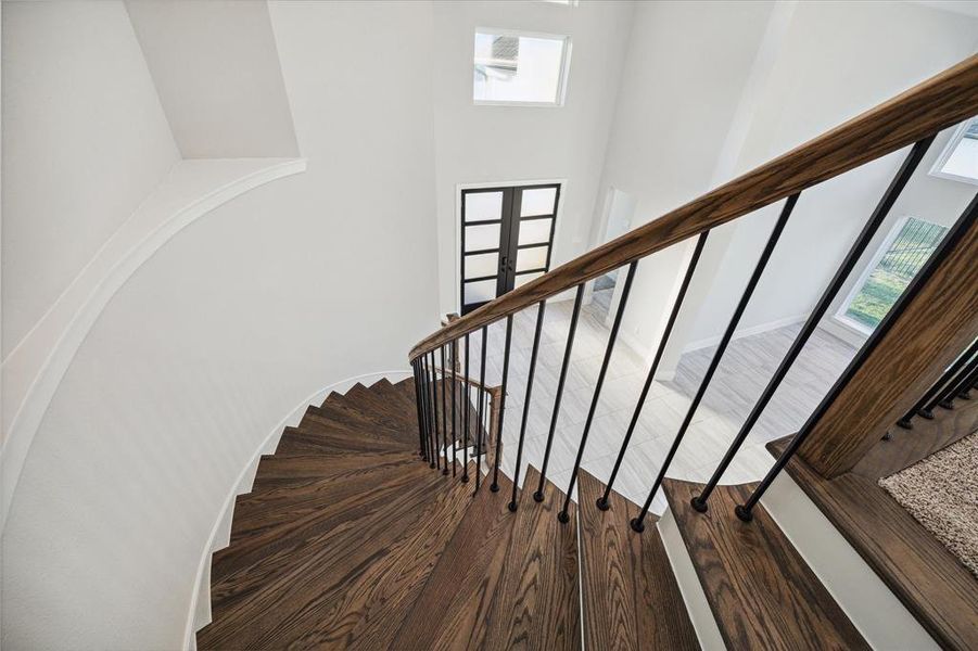 This elegantly curved staircase is simple beautiful! There is also a second staircase located at the back of the house.