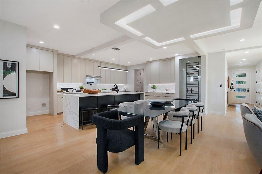 Dining space with sink and light wood-type flooring