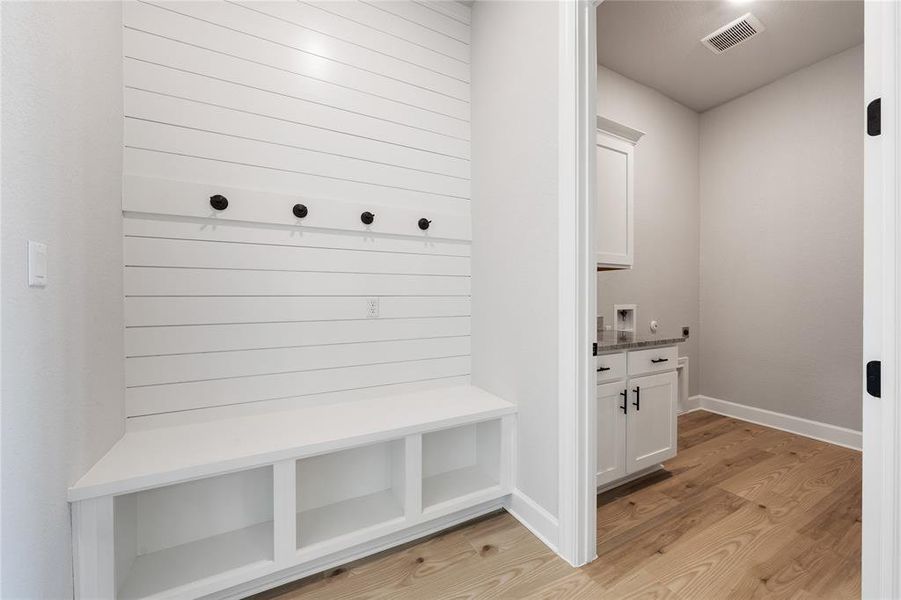 Mudroom and laundry room are conveniently adjacent as you enter from the garage.