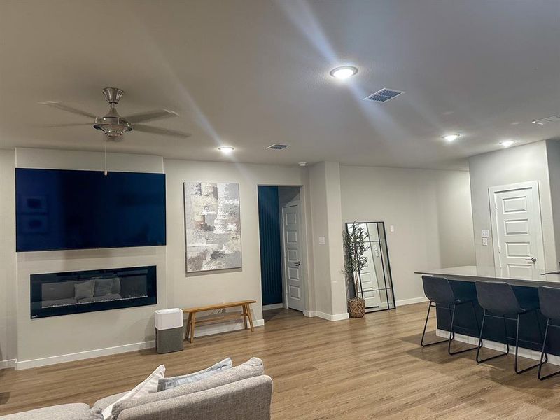 Living room with light hardwood / wood-style flooring and ceiling fan