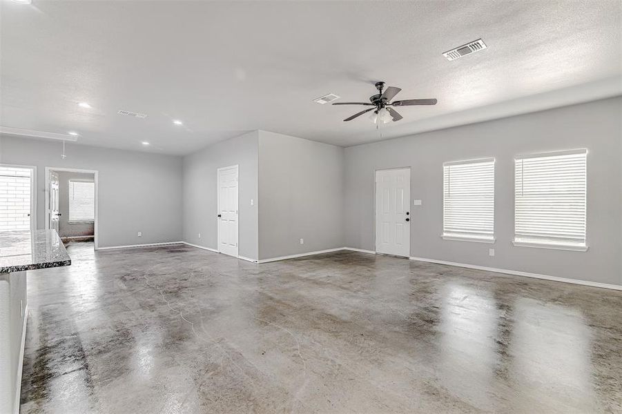 Empty room with concrete floors, a textured ceiling, and ceiling fan