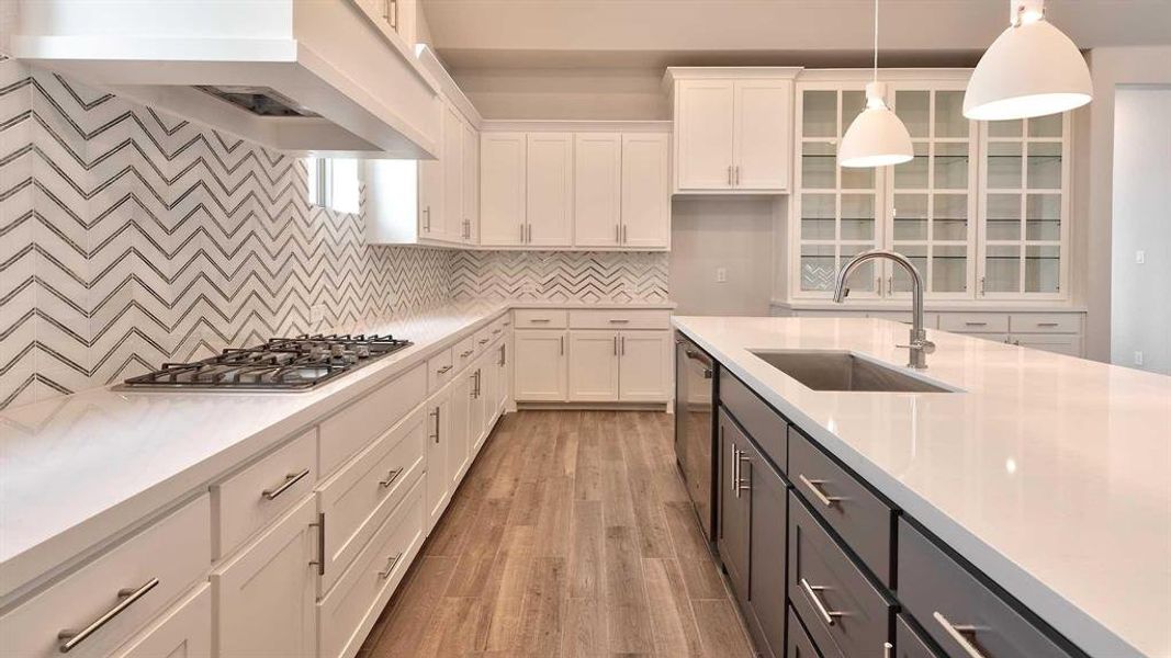 Kitchen featuring appliances with stainless steel finishes, sink, light hardwood / wood-style floors, white cabinetry, and wall chimney exhaust hood