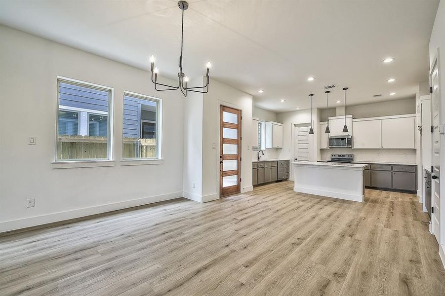 Kitchen with pendant lighting, white cabinetry, plenty of natural light, and a center island