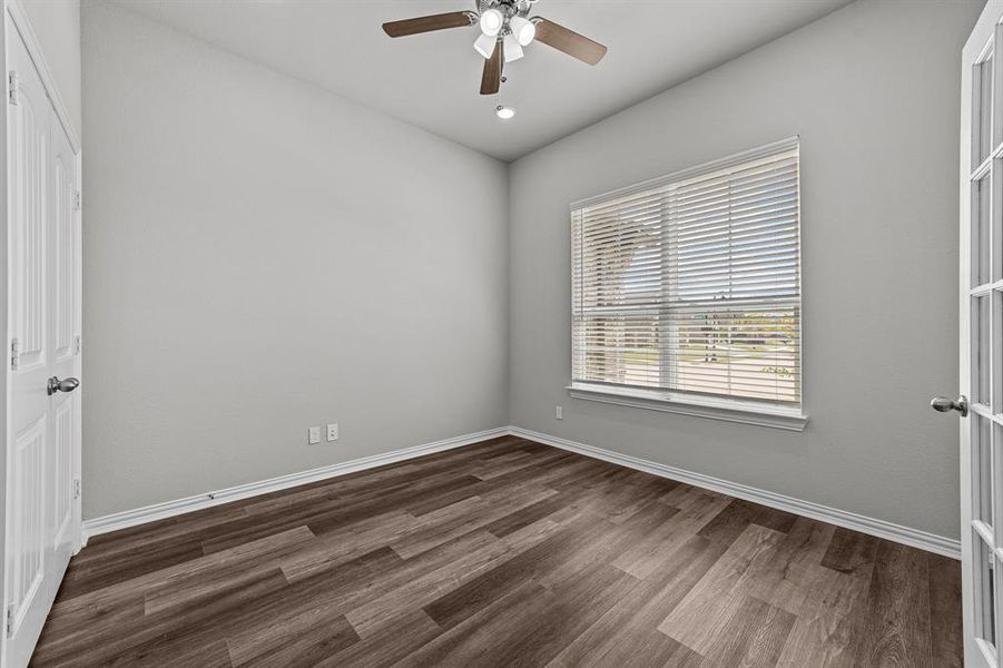 Empty room featuring dark hardwood / wood-style flooring and ceiling fan