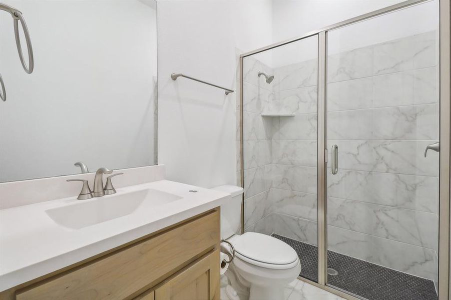 2nd Bathroom featuring walk in shower, tile flooring, vanity, and toilet