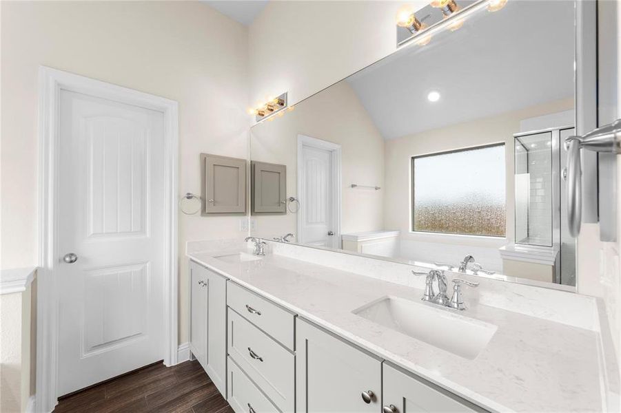 Bathroom with hardwood / wood-style floors, lofted ceiling, walk in shower, and vanity