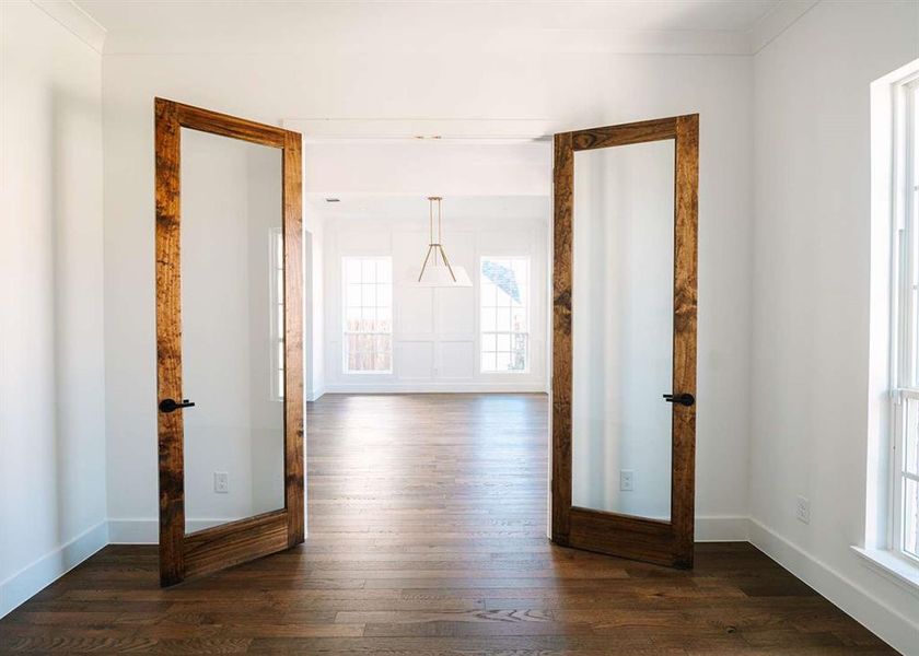 Hall featuring crown molding, dark wood-type flooring, french doors, and a wealth of natural light