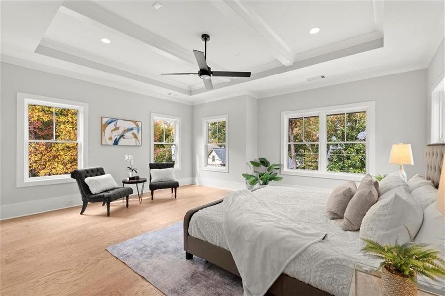 Bedroom with a tray ceiling, ceiling fan, light hardwood / wood-style flooring, and beam ceiling