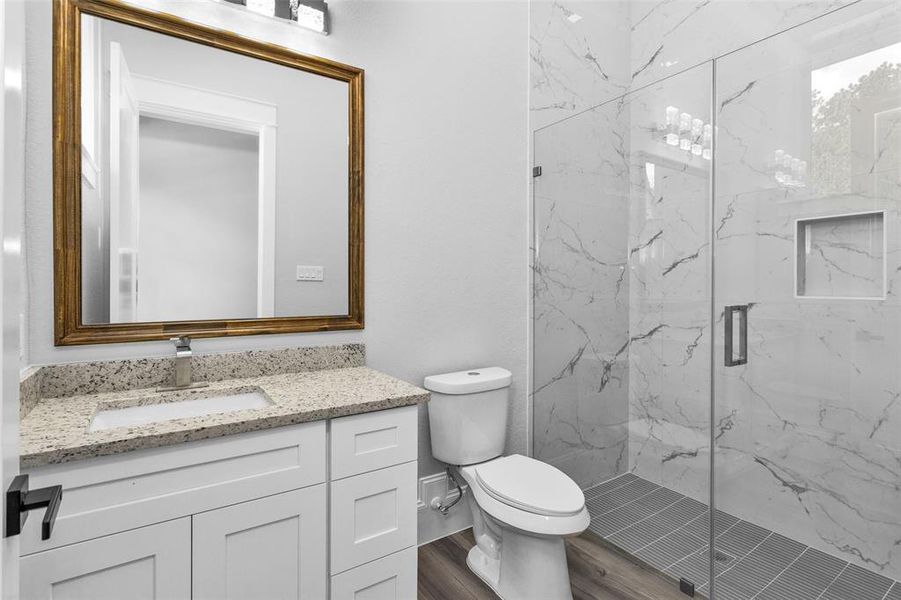 Bathroom #2. All Secondary Bathrooms offer walk-in showers with frameless glass and large inset storage and the same clean modern finishings used throughout the home, along with Delta sinks, faucets and shower shower finishings.
