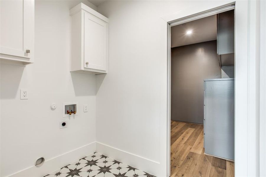 Laundry area with cabinets, light wood-type flooring, washer hookup, electric dryer hookup, and gas dryer hookup