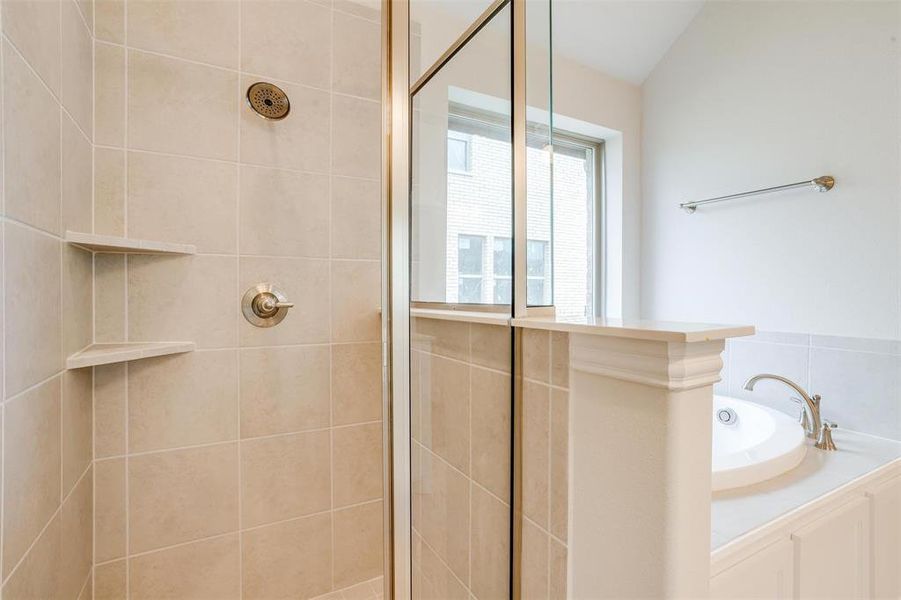 Bathroom featuring shower with separate bathtub and vaulted ceiling